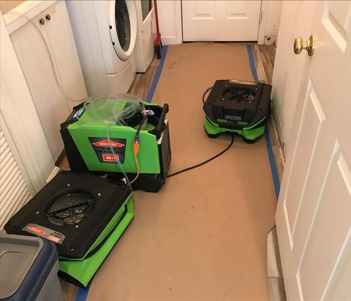 Three green air movers in a hallway.